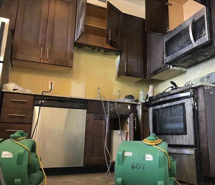 post-fire kitchen mess with fans on the floor