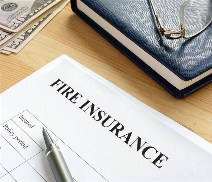 fire insurance form with pen and money on table